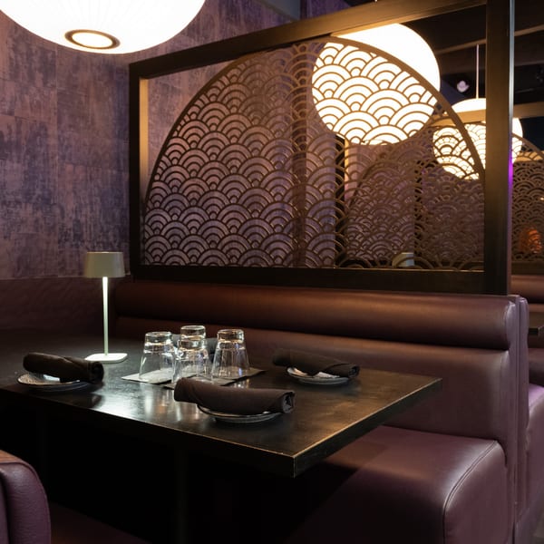 Lemongrass Asian Bistro's dining area with dark tables, purple booths, and decorative Asian screens.
