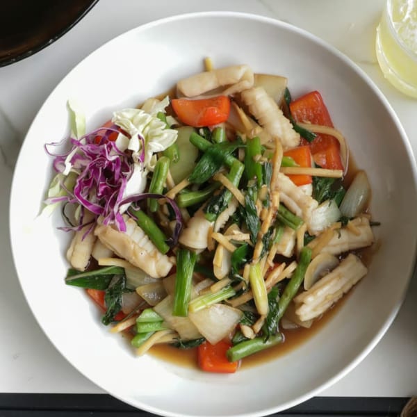 Lemongrass Asian Bistro's stir-fried calamari with vegetables and ginger in a white bowl.