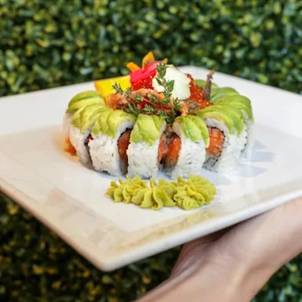 Lemongrass Asian Bistro's sushi roll, topped with avocado, roe, and herbs, served with wasabi.